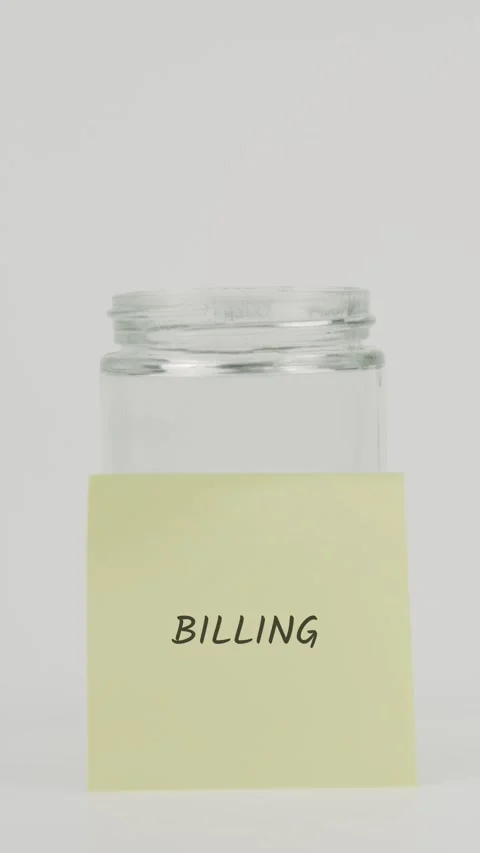 Billing text or word on yellow sticky note attached to glass jar with hand Stock Footage 311681870