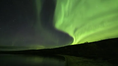Billowing Aurora Borealis over a sandy bay Stock Footage 250294430