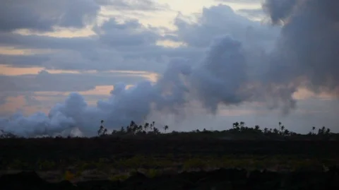 Billowing clouds pass over a rocky landscape during sunset. Stock Footage 88342891