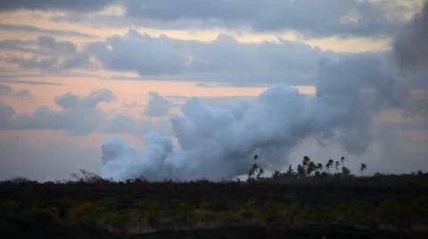Billowing clouds pass over a rocky landscape during sunset. Stock Footage 88342895