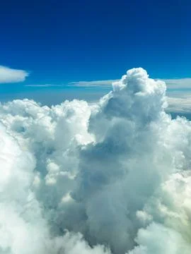 Billowing clouds tower gracefully, reflecting sunlight while creating a dream Stock Photos