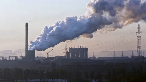 Billowing steam from smoke stack filling sky. Smoking chimneys of a steel pow 動画素材 112775264