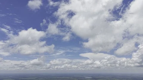 Billowing White Clouds Over Wide River Plain Under Midday Sky Stock Footage 344270874