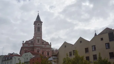 Billowy clouds rush by a steeple in Landshut, Germany time lapse Stock Footage 70794092