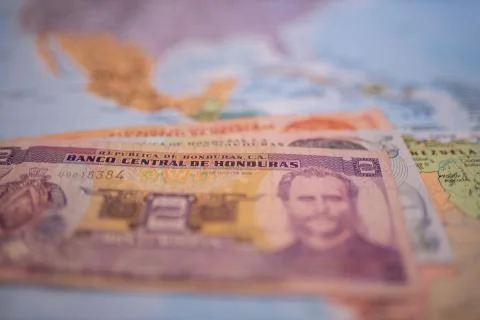 Bills of one, five, and two lempiras under Honduras on a blurry America map Stock Photos