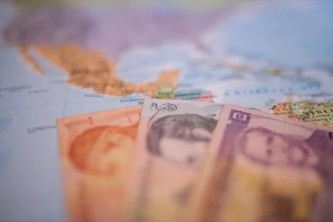 Bills of one, five, and two lempiras below Honduras on a blurry America map Stock Photos