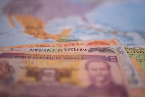 Bills of one, five, and two lempiras below Honduras on a blurry America map Stock Photos