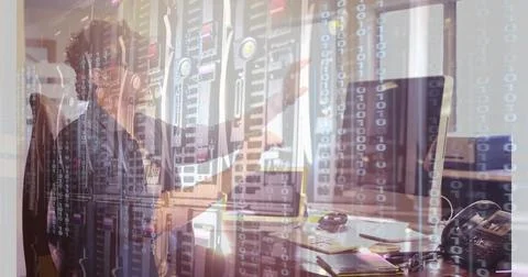 Binary code and data servers over person working at computer in office 库存照片