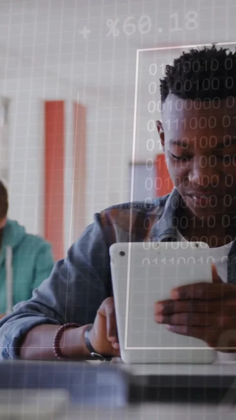 Binary code animation over students using tablets and writing in classroom Stock Footage 342954397