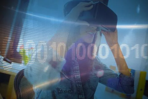 Binary code on digital screen against woman using virtual reality headset 스톡 사진
