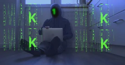 Binary code instead of face of a hooded programmer sitting on floor with laptop 库存照片