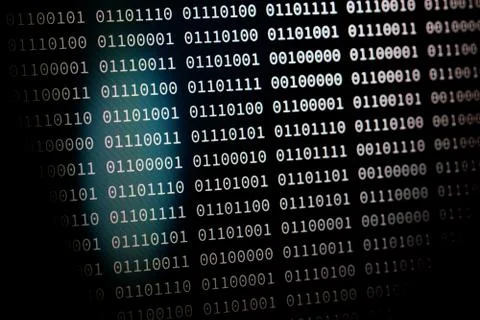 Binary code one and zero series on computer screen with focus on the light an Stock Photos