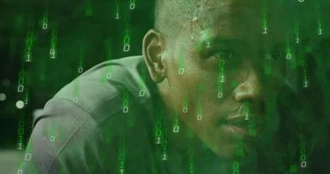 Binary code overlaying man's face, concentrating on digital work in office 動画素材 305519242