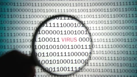 Binary code with a red label virus is viewed with a magnifying glass. 스톡 동영상 144624503