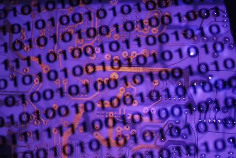 Binary code superimposed on a circuit board Stock Photos