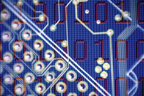 Binary code superimposed over a circuit board Stock Photos