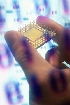 Binary code superimposed over a persons hand holding a computer chip Stock Photos
