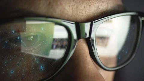 A binary code of zeros and ones is reflected on the glasses on a man's face. The Video stock 256140724