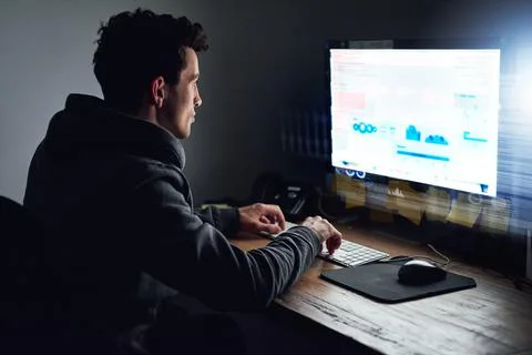 Binary is his second language. Rearview shot of a young programmer working on Stock Photos