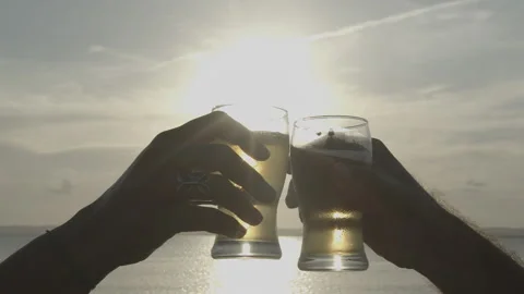 Binde de copo de cerveja com sol ao fundo a beira mar 動画素材 169030412