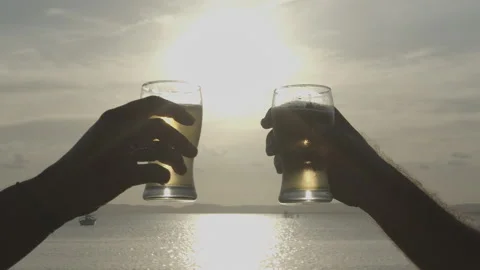 Binde de copo de cerveja com sol ao fundo a beira mar Stock Footage 169030433