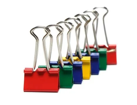 Binder clips colored on white background, shallow DOF Stock Photos