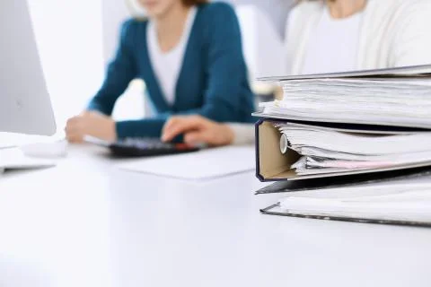 Binders with papers are waiting to be processed by business woman or bookkeeper Stock Photos