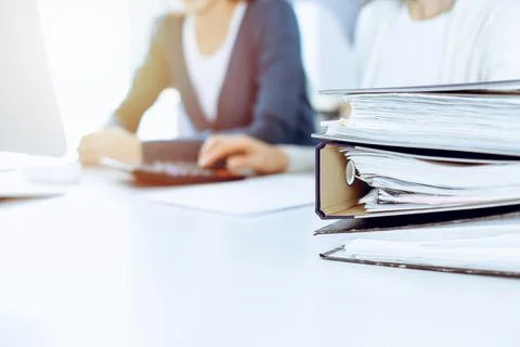 Binders with papers are waiting to be processed by business woman or bookkeeper Stock Photos