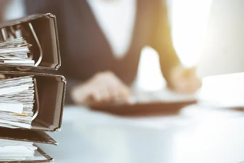 Binders with papers are waiting to be processed by business woman or bookkeeper Stock Photos