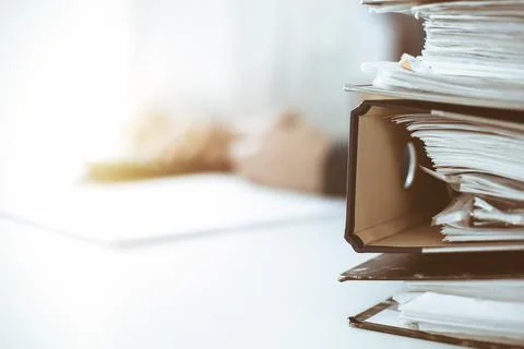 Binders with papers are waiting to be processed by business woman or bookkeeper Stock Photos