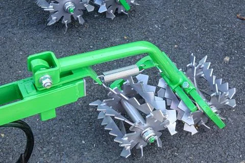 Bineuse batteuse is displayed showcasing sharp metal blades attached to a gre Stock Photos