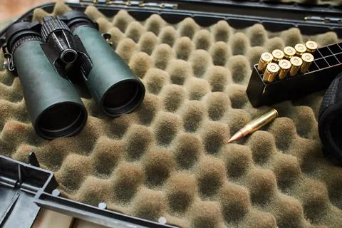 Binocular and bullets on the dark background. Stock Photos
