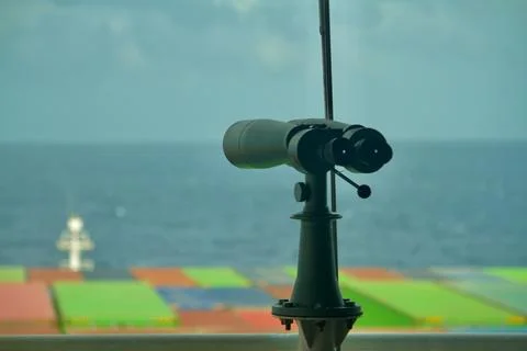 A binocular fixed on the bridge of a container ship underway at sea in the .. Stock Photos