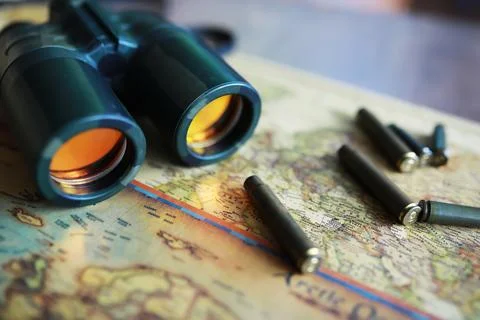 Binoculars and reflection in lenses. Map and shells background. Foto stock