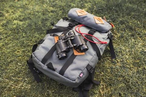 Binoculars backpack grass Stock Photos