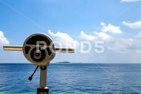 Binoculars to observe an island in the sea Stock Photos