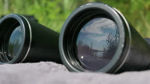 Binoculars Resting on Blanket Outdoors Overlooking Lake Close-Up Stock Footage 345173465