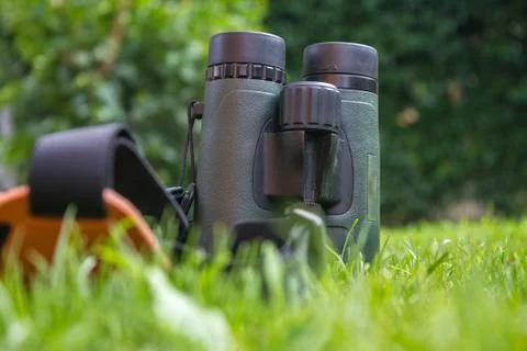 Binoculars with strap on Grass Stock Photos
