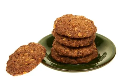 Bio cereal biscuits with chocolate chips and nuts isolated on a green plate 库存照片