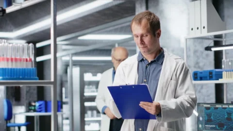 Bio science expert focuses on experiment data in a research study Stock Footage 317785726