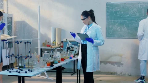 In the biochemical lab group of scientist using digital tablet and blackboard to Video stock 153087135
