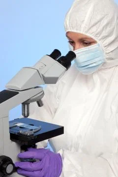 Biochemist looking through a microscope Stock Photos