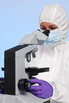 Biochemist looking through a microscope Stock Photos