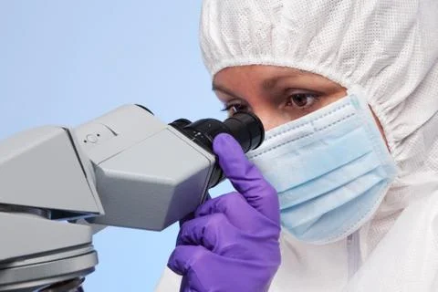 Biochemist looking through a microscope Stock Photos