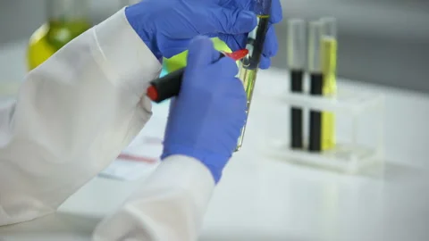 Biochemist marking reaction product sample, successful experiment, biofuel Stock Footage 103344196