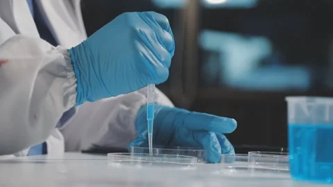 Biochemistry, scientist pipetting a sample into a test tube during an exper.. Stock Footage 290061034
