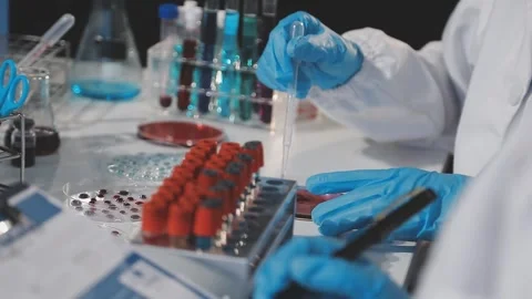 Biochemistry, scientist pipetting a sample into a test tube during an exper.. Stock Footage 290061551