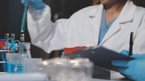 Biochemistry, scientist pipetting a sample into a test tube during an exper.. Stock Footage 290061597