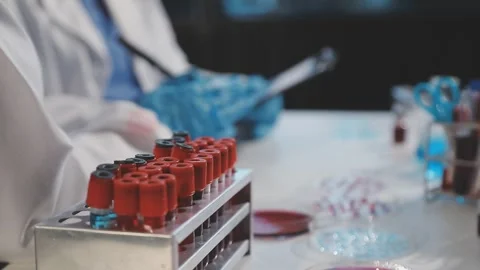 Biochemistry, scientist pipetting a sample into a test tube during an exper.. Stock Footage 290061699