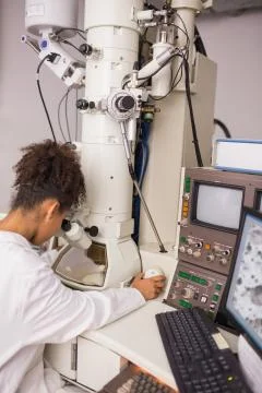 Biochemistry students using large microscope and computer 스톡 사진